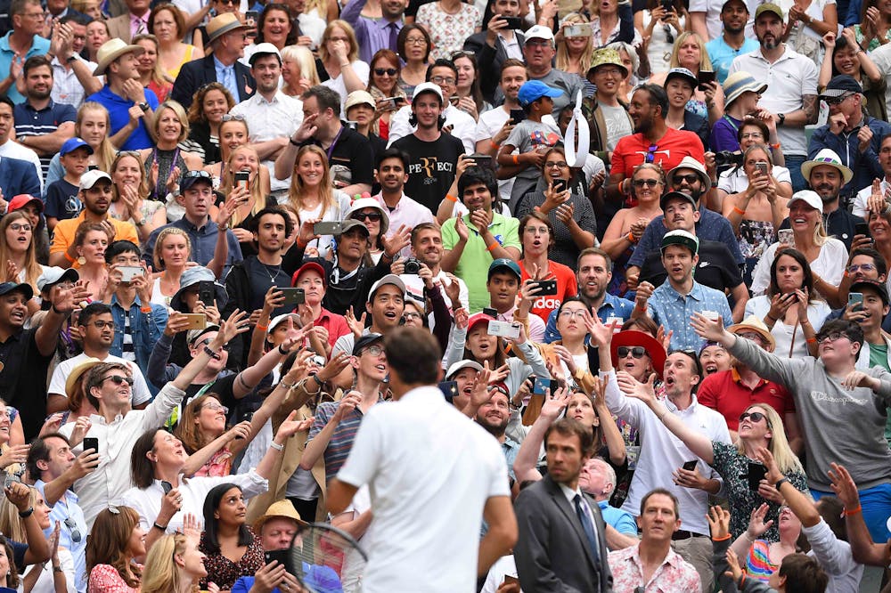 Astonished crowd as Roger Federer throws his headband to them at Wimbledon 2019.