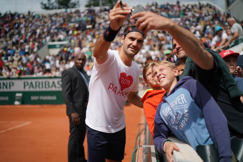 Roger Federer helps out with a selfie on Kids Day.
