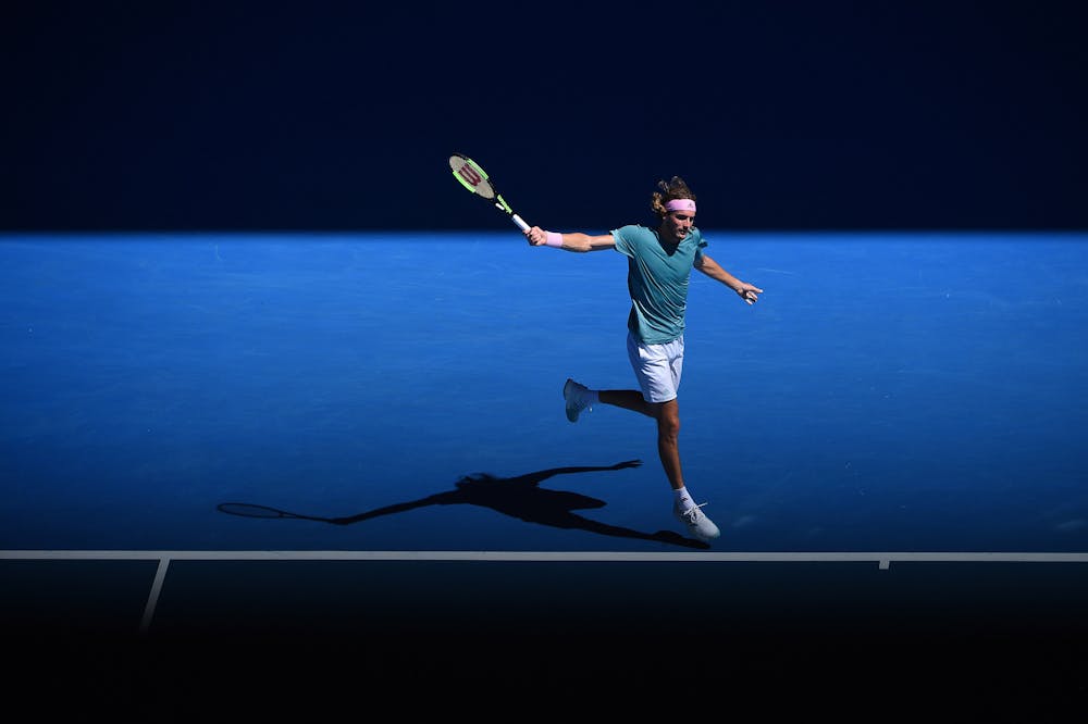 Stefanos Tsitsipas hitting a backhand in the beautiful light of the 2019 Australian Open