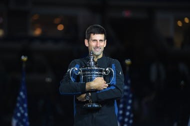 Novak Djokovic smiling while holding the trophy US Open 2018