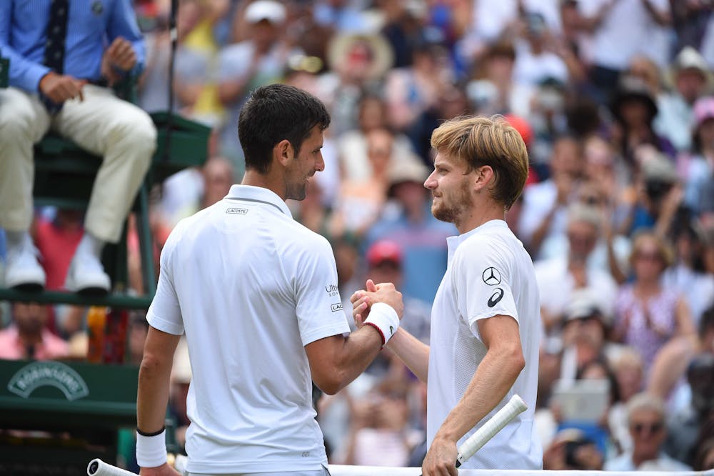 Novak Djokovic and David Goffin at the net at Wimbledon 2019.