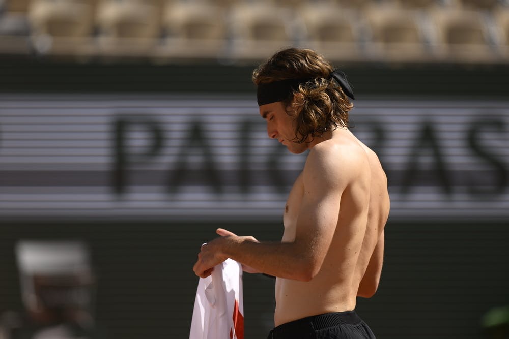 Stefanos Tsitsipas changes his shirt during practice at Roland-Garros 2023