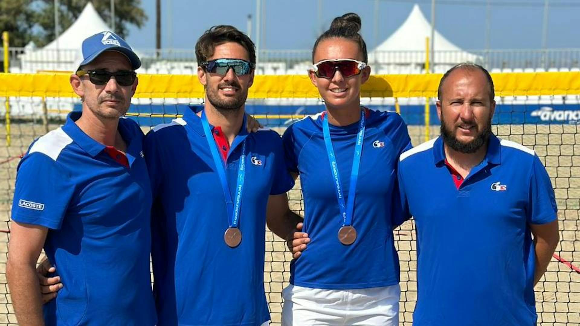 Théo Irigaray et Lola Barrau, médaille de bronze autour du cou, entourés de leurs entraîneurs