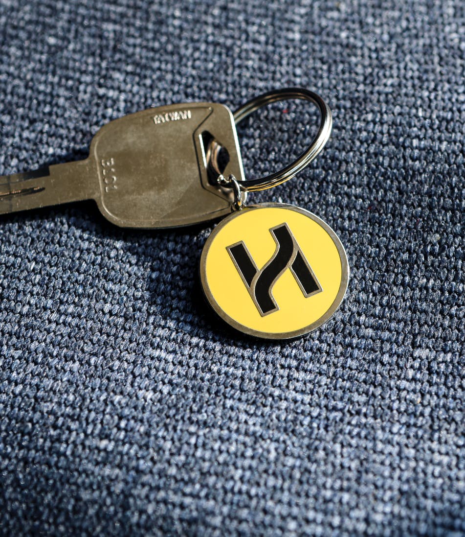 A key with a keychain showcasing the Highland logo "H".