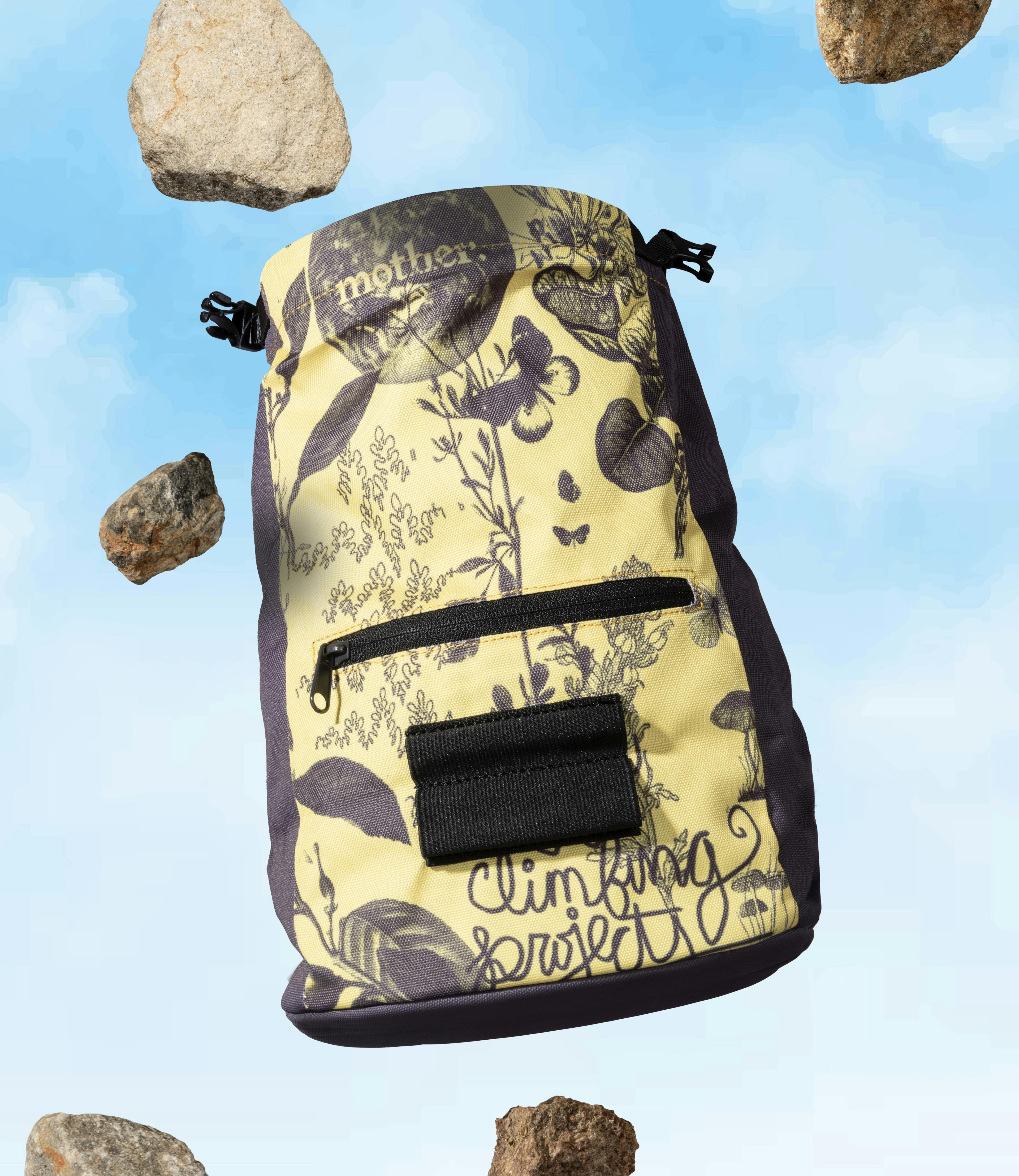 An Evolv chalk bag floats overtop a blue sky.