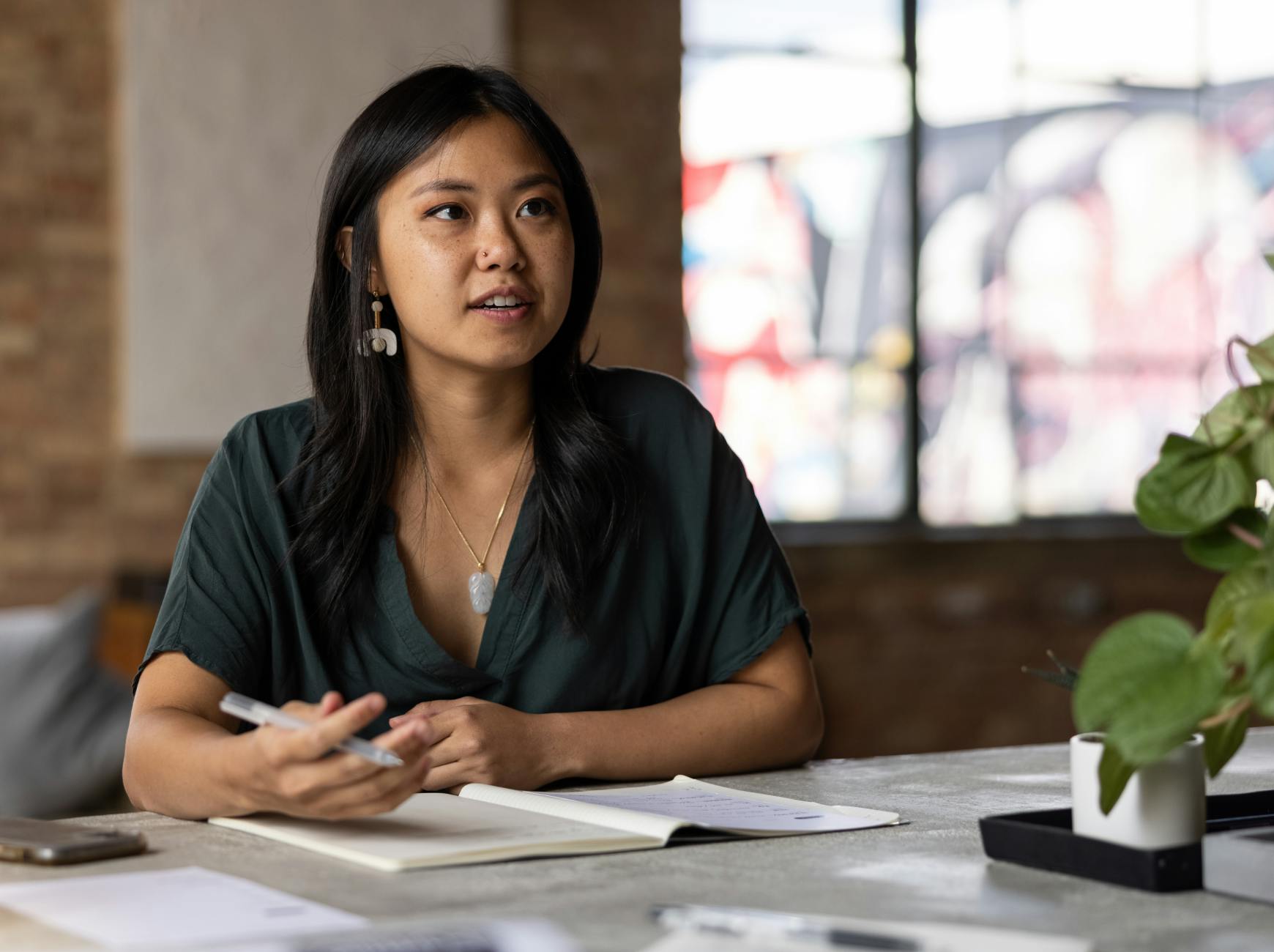 Figure employee sits at a desk talking to another participant during a Figure workshop.