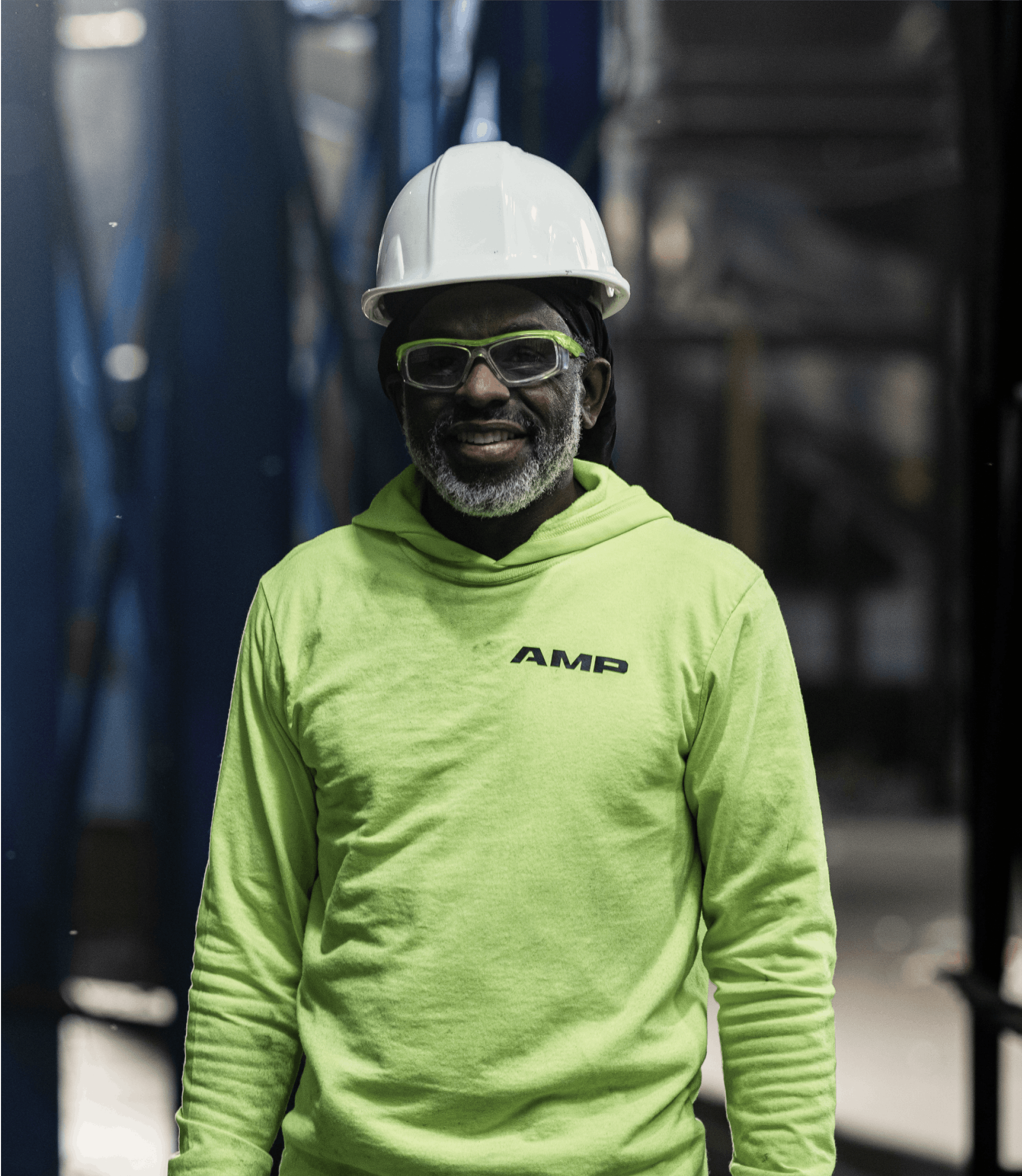 A portrait of a waste facility employee, smiling and wearing AMP gear.