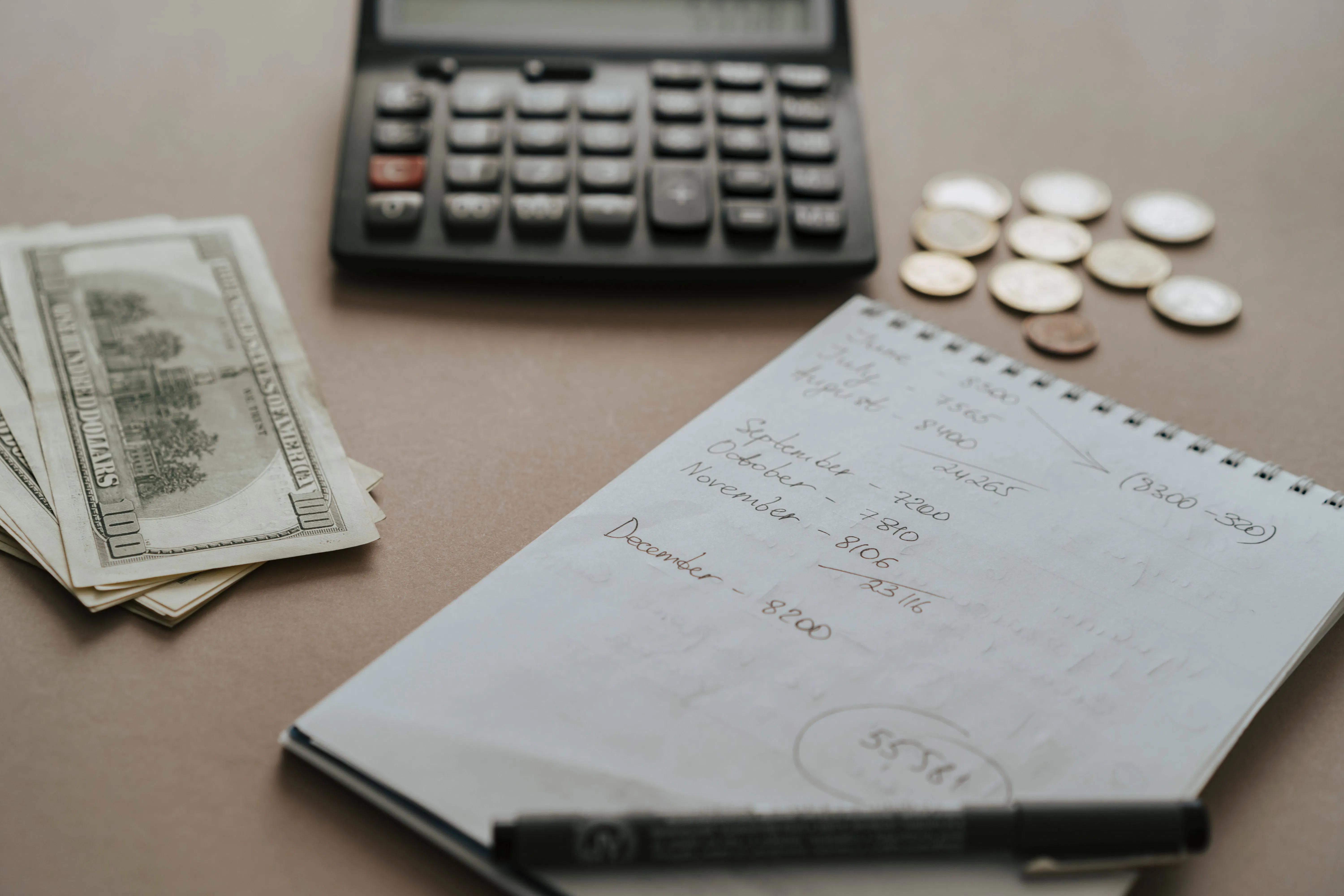 caderno, calculadora e dinheiro