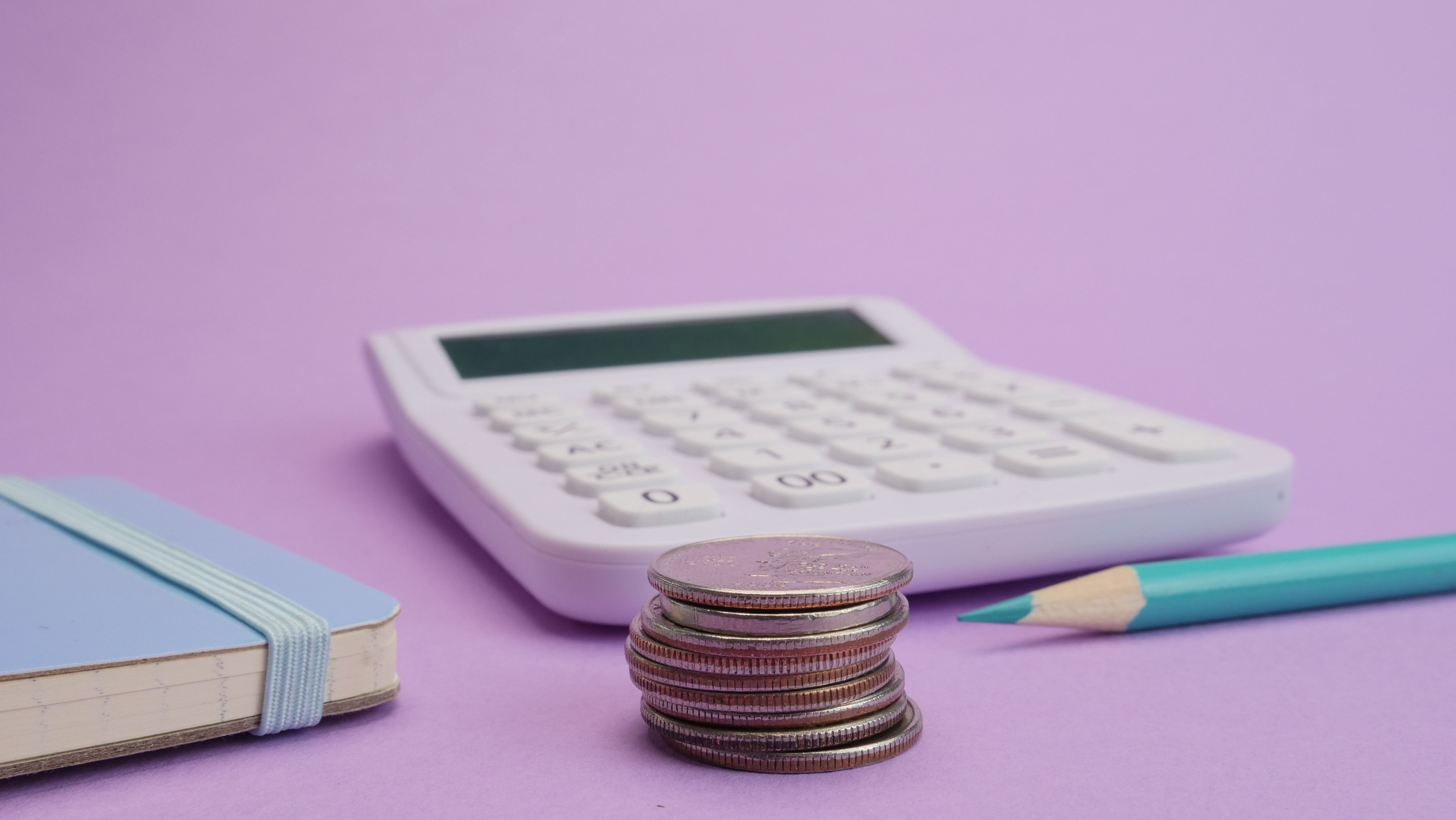 calculadora, moedas, lápis e bloco de notas