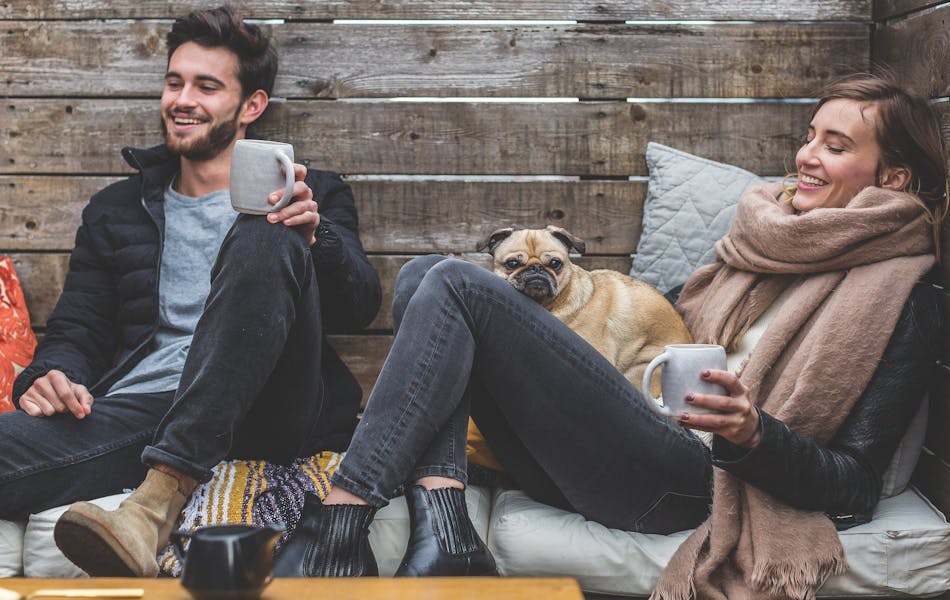couple drinking coffee with pug