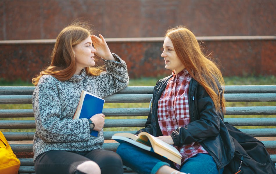 two women talking on a bench