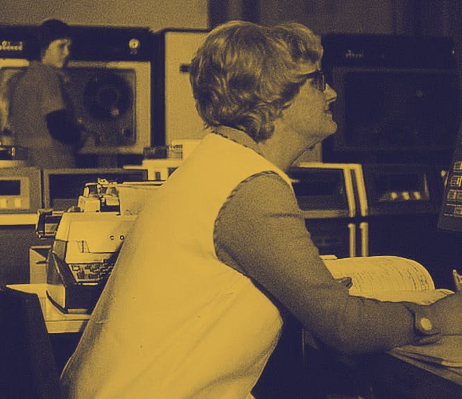 A woman looking at an old computer