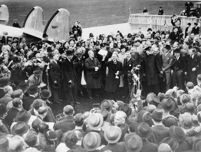 Black and white photograph of Neville Chamberlain talking to a crowd.
