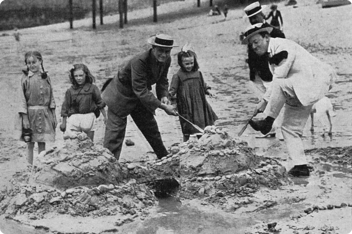 Vintage photo of people building sandcastles