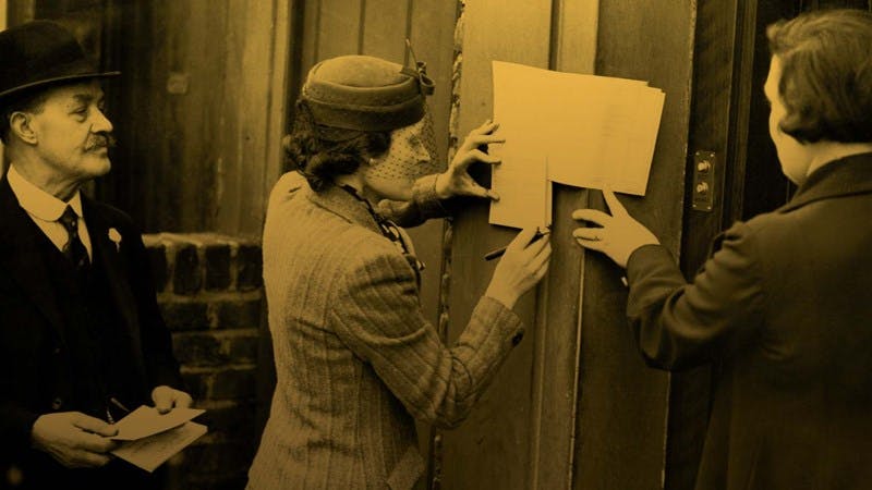 Photo with a yellow tint of three people filling in their 1939 registration papers on a door