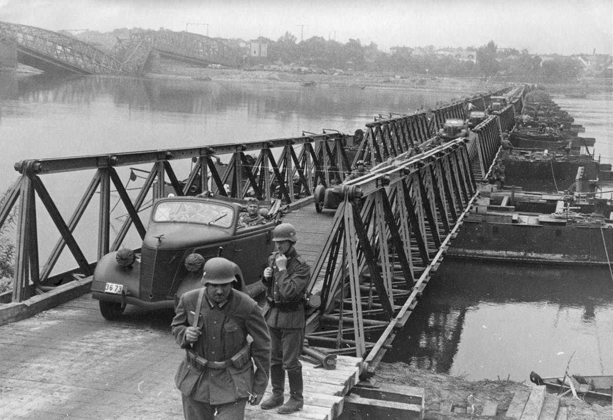 A black-and-white photograph of vehicles crossing over a river.