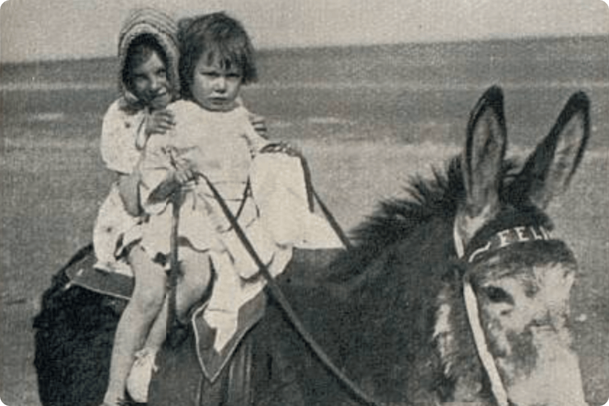 Vintage photo of children riding a donkey at the beach
