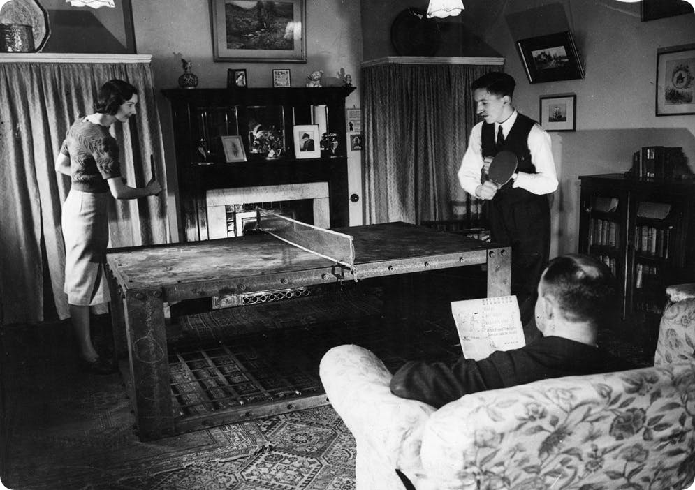 A game of table tennis taking place on top of a Morrison Shelter in World War 2