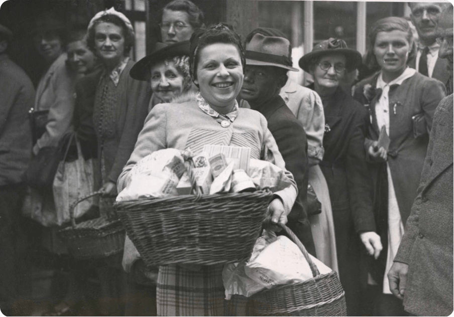 A smiling woman receiving a basket of food