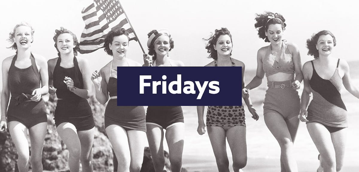 An old photo of women on a beach with an American flag