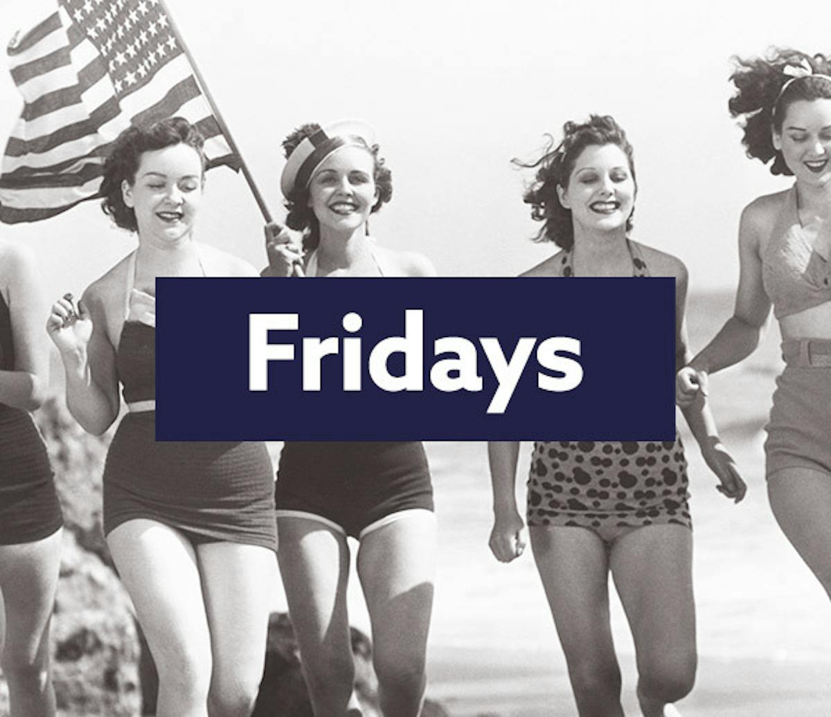 An old photo of women on a beach with an American flag