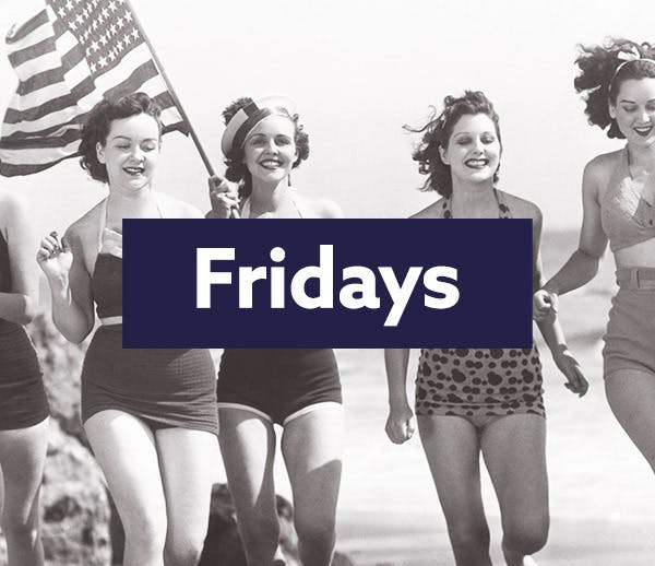 An old photo of women on a beach with an American flag