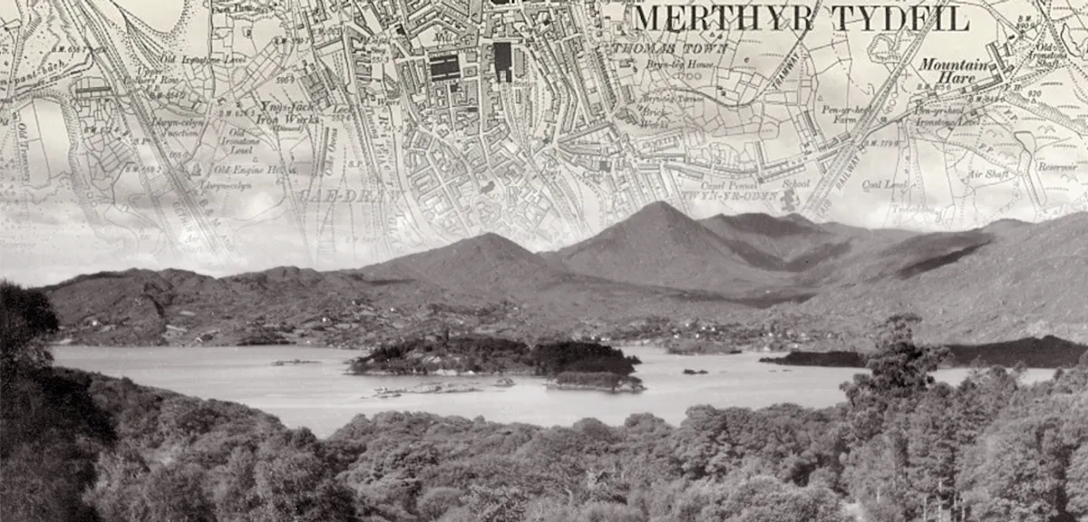 Black and white photo of a lake, with an old map of Merthyr Tyfil fading into the sky