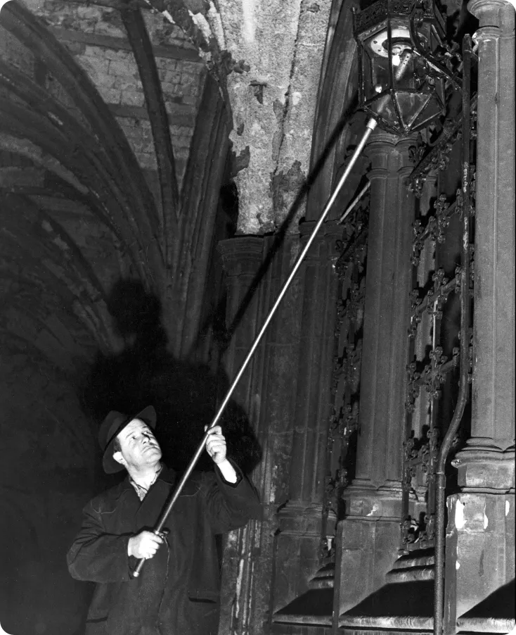 lamplighter lighting a gas lamp