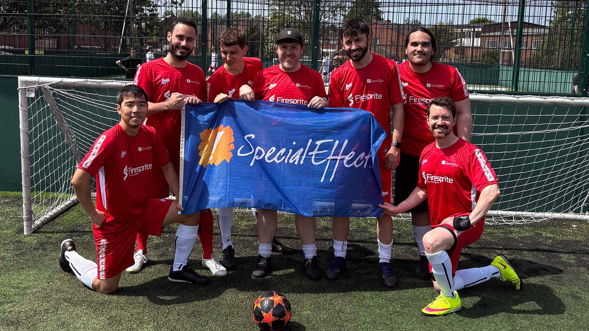A close-up of a desk scene in an office, with soft overhead lighting and empty seats. 