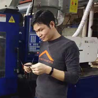 Manufacturer inspecting injection moulded part