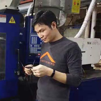 Manufacturer inspecting injection moulded part