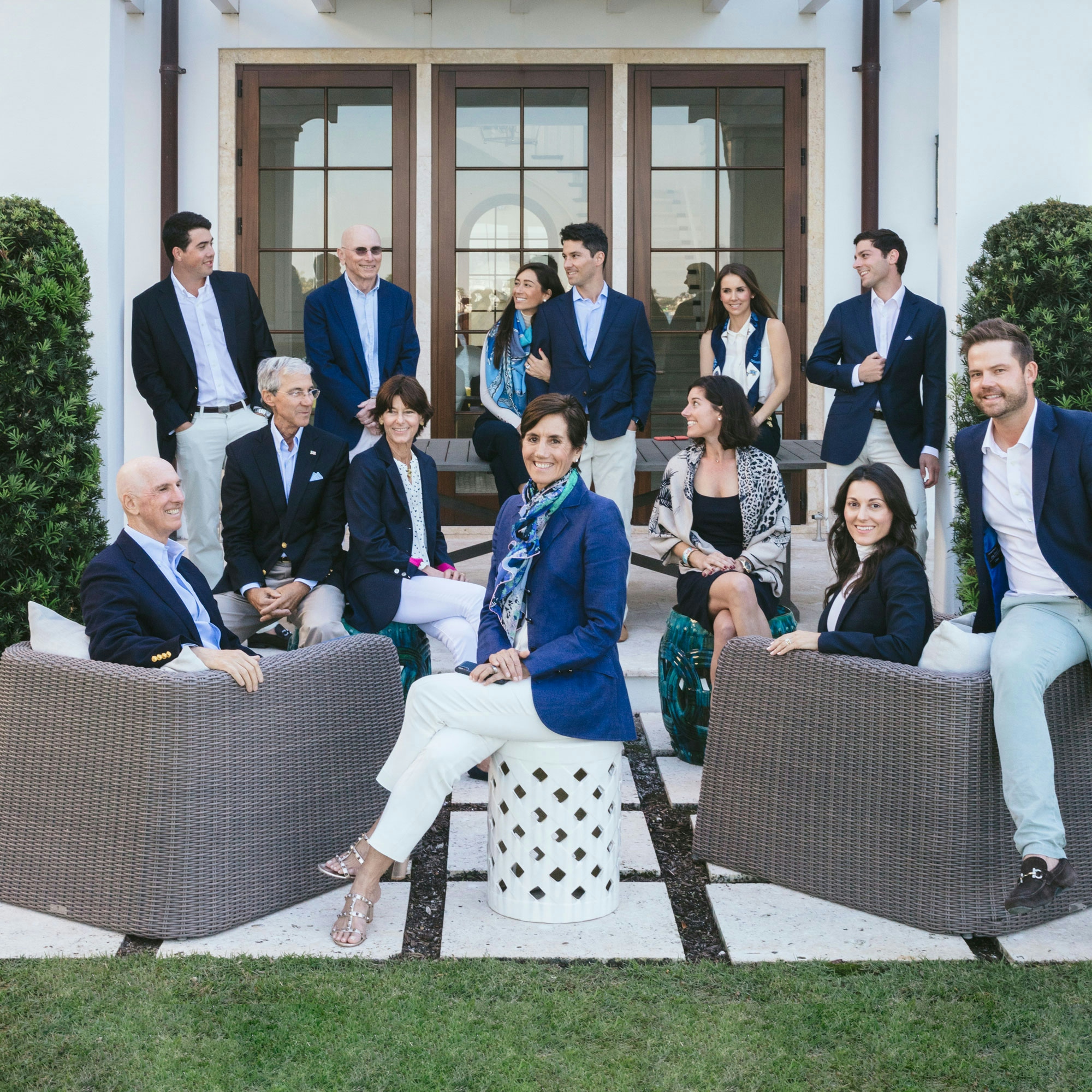 Group of people in business suits sitting and standing for Frisbie Group.