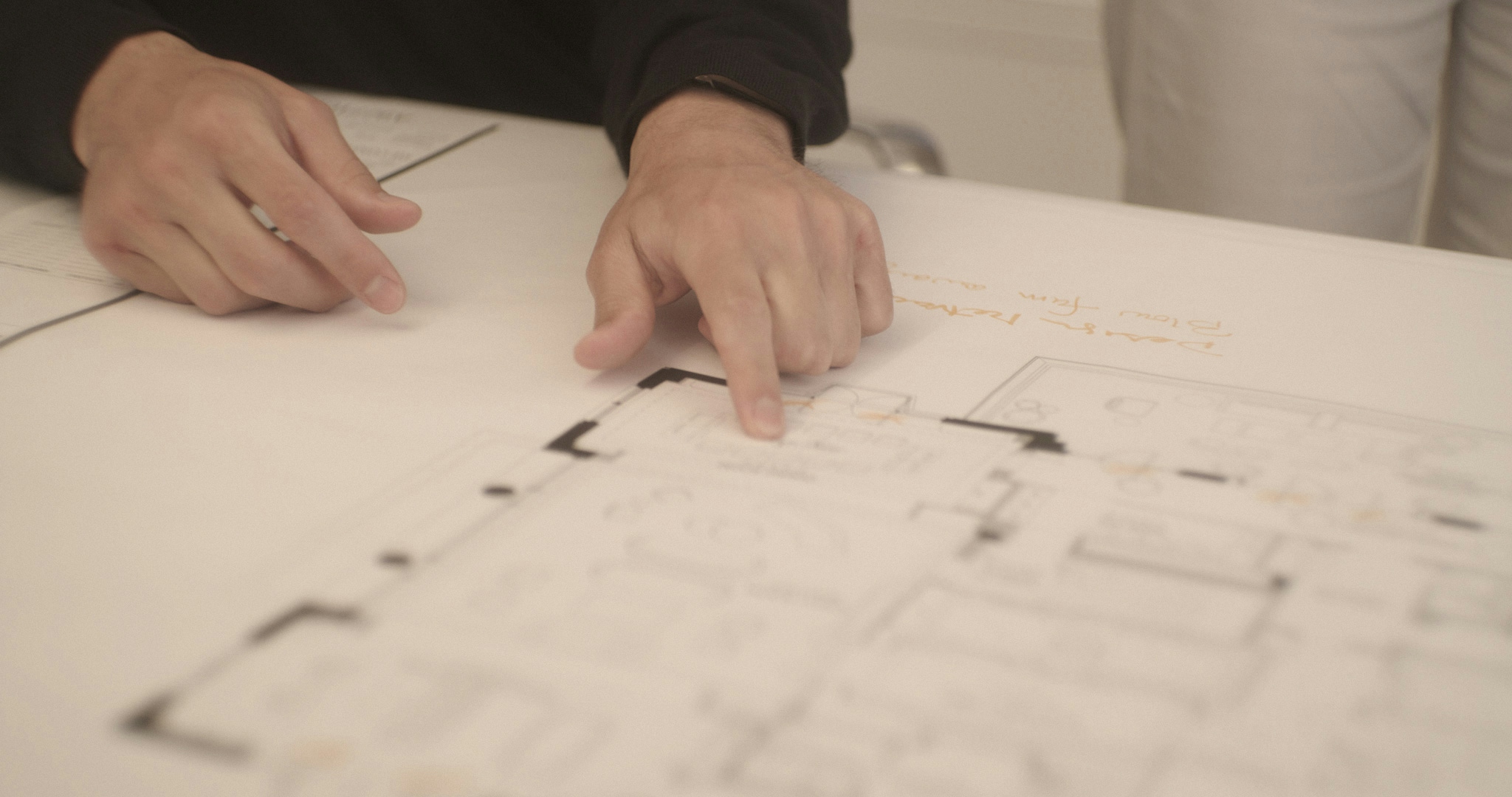 Person pointing at architecture plans.