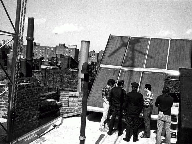 Police offer on roof of building with windmill shadow - flexfarmd building renewable energy microgrids