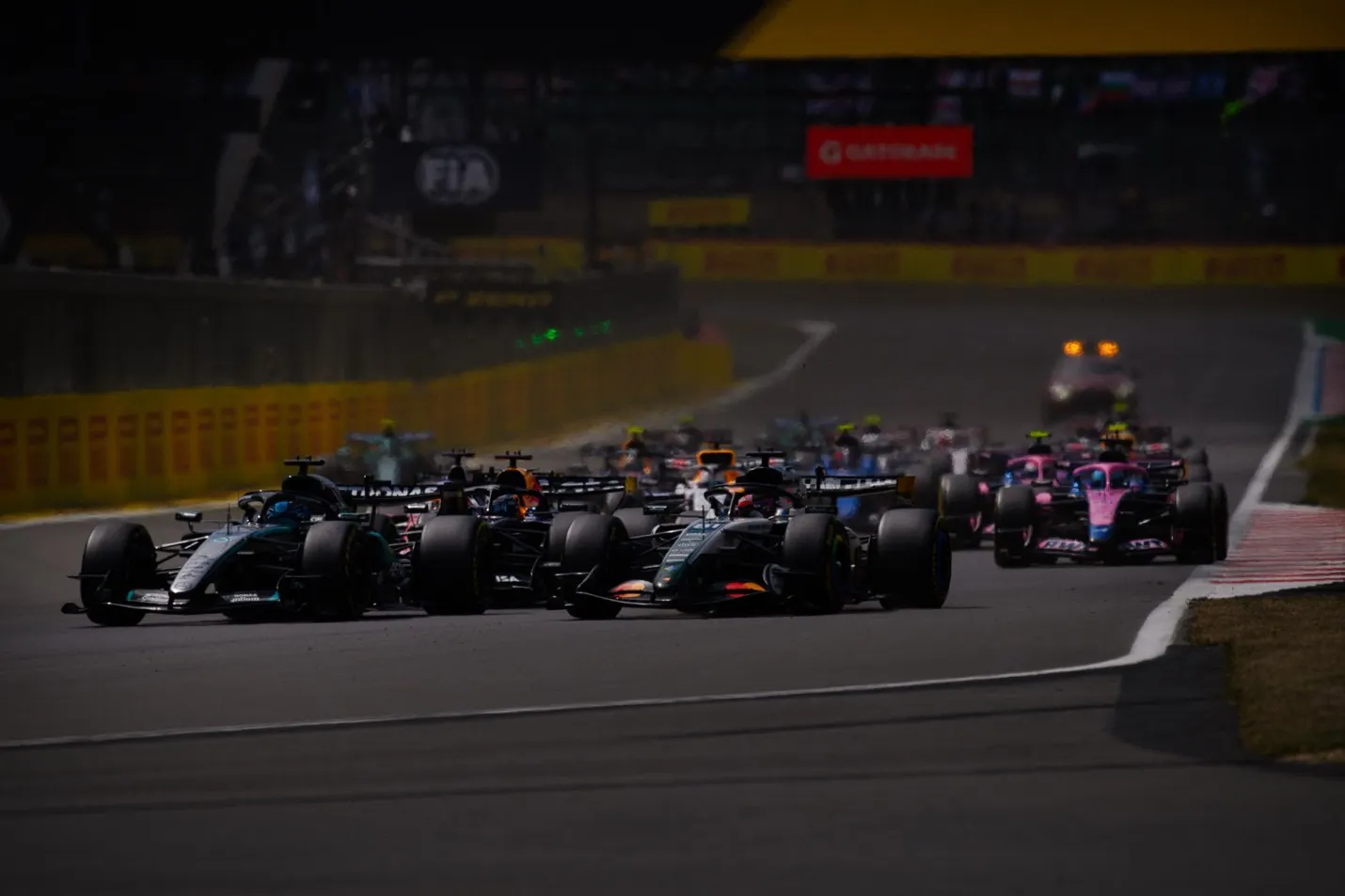 f1 cars racing around a bend