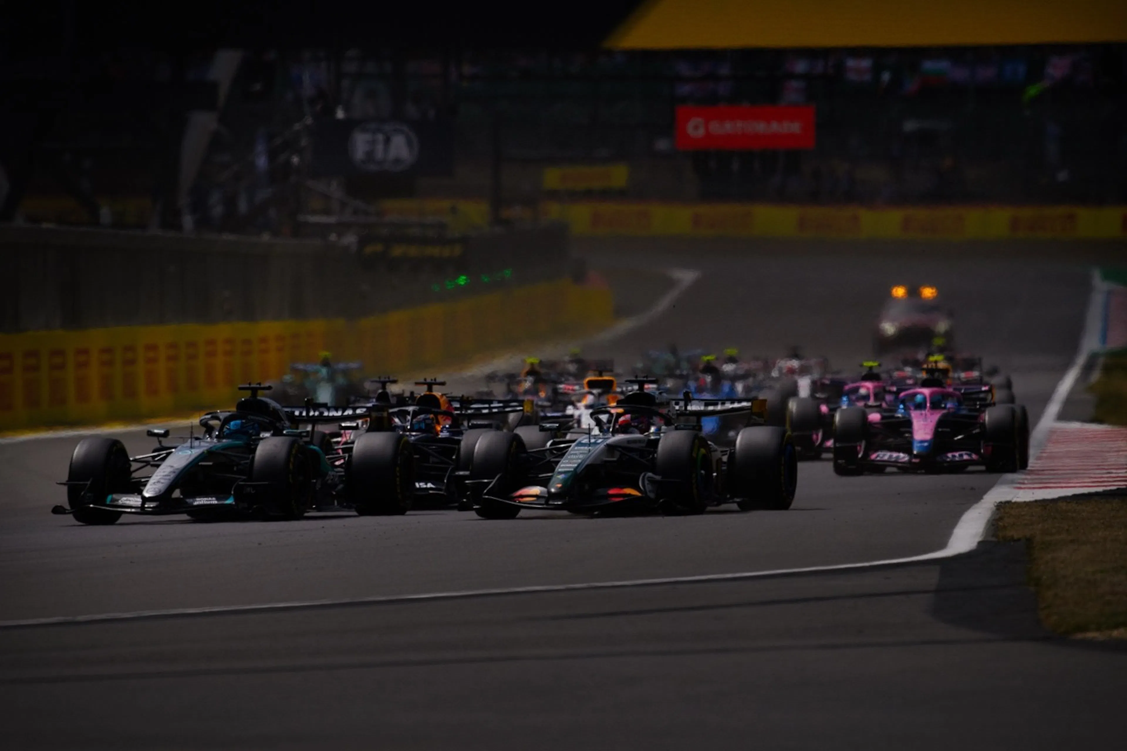 f1 cars racing around a bend