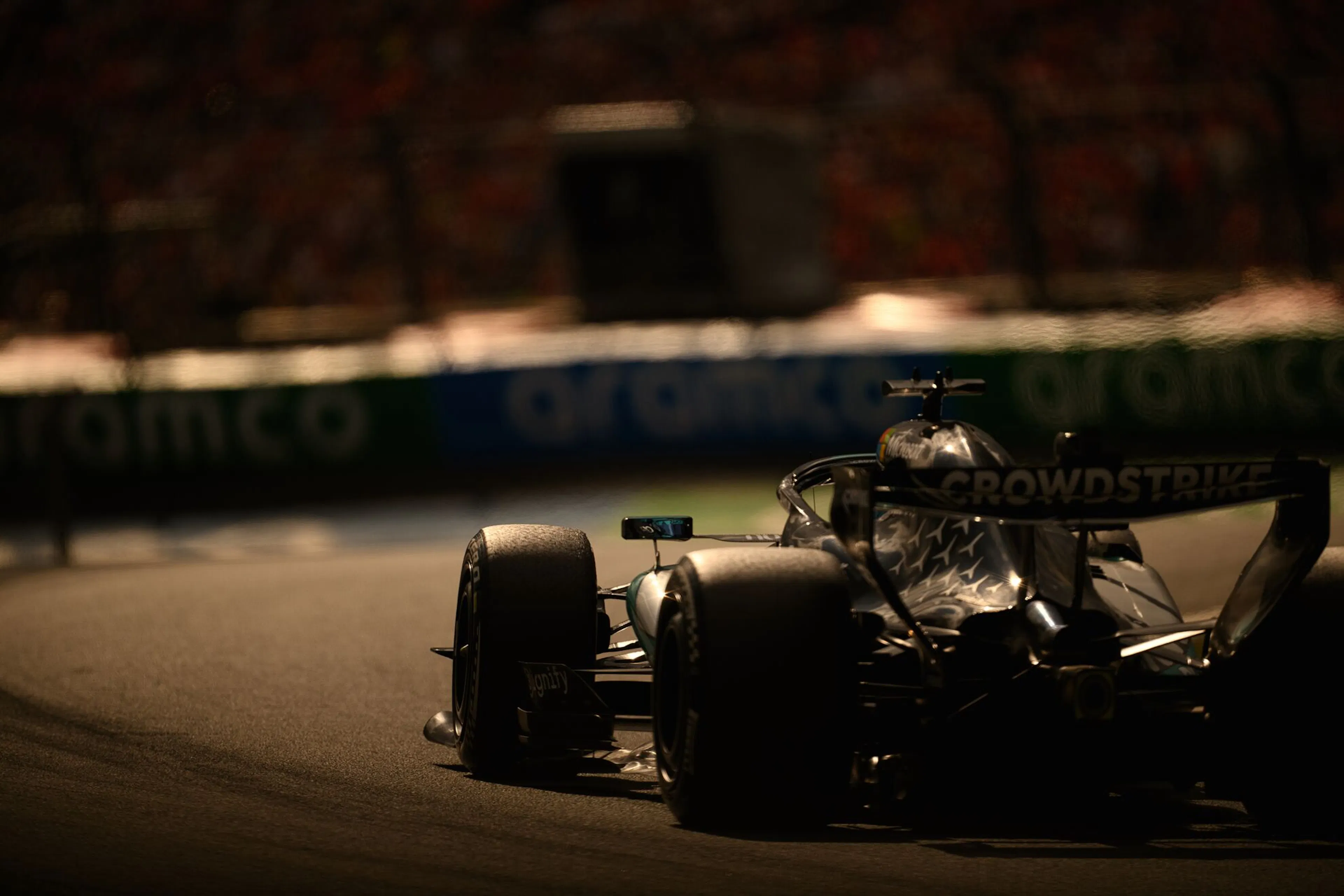 Dark tinted photo of an F1 car racing around a turn