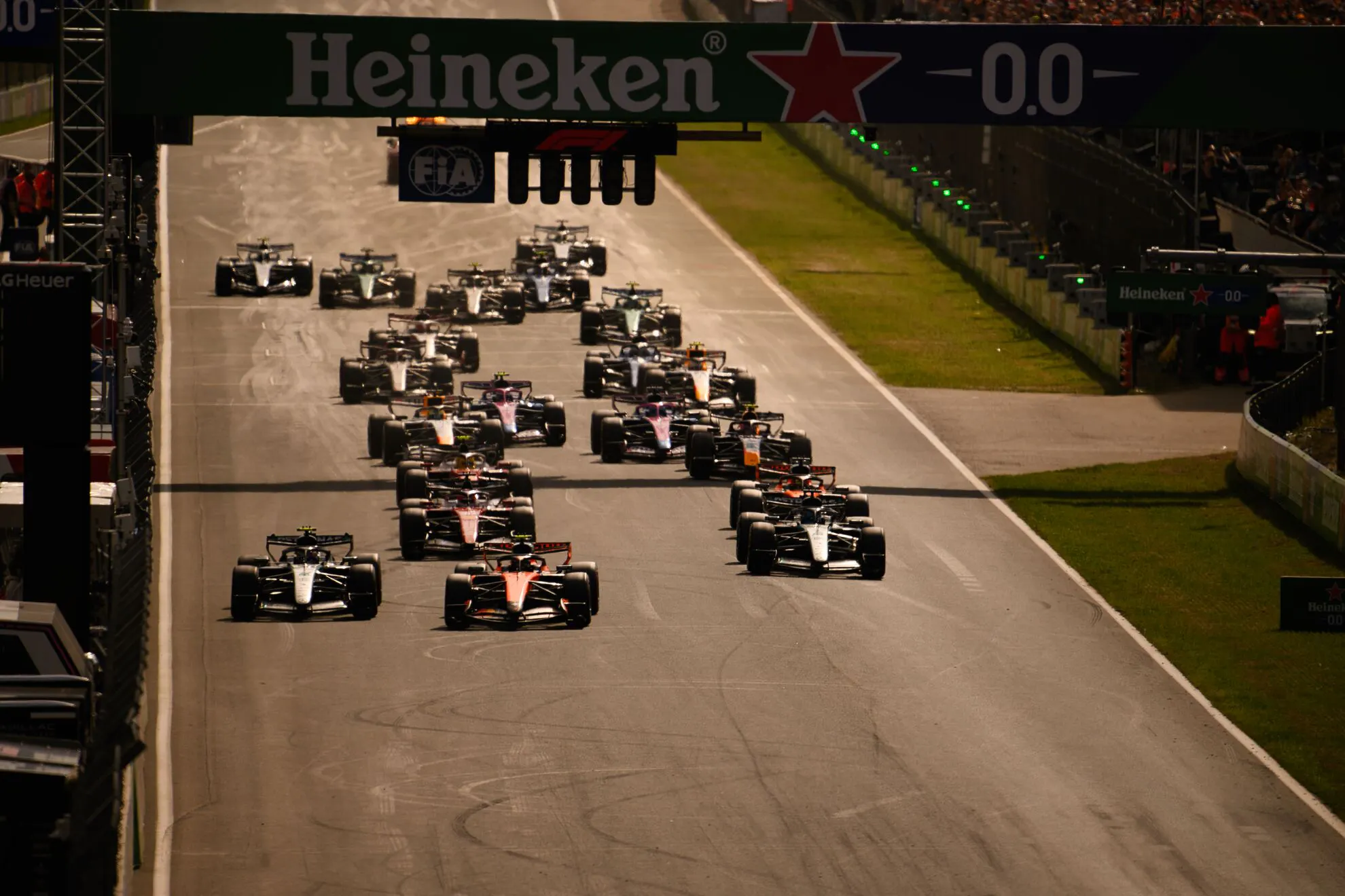 A number of F1 cars clustered on a straight-away