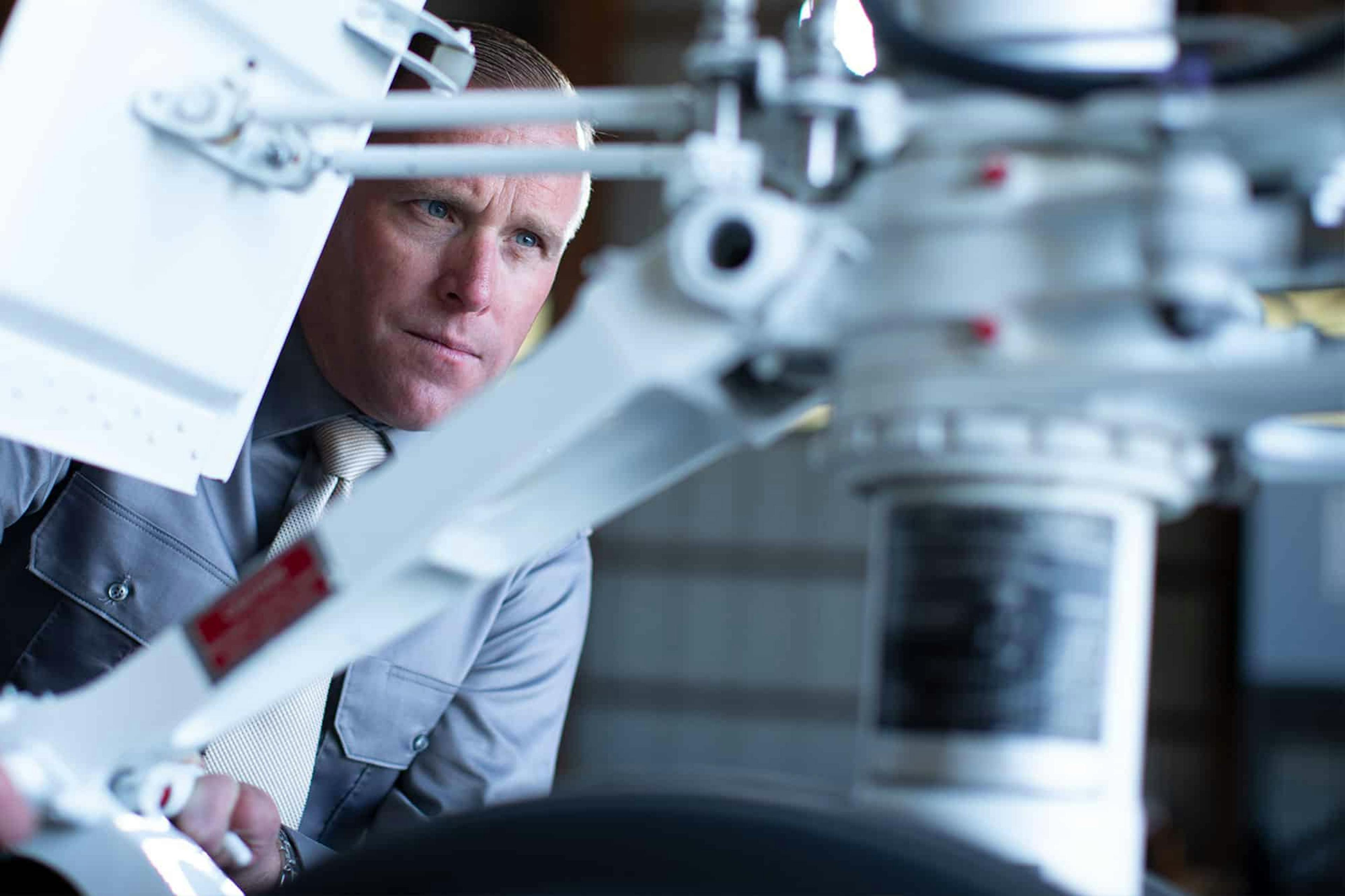 A man looks on with focus at some aircraft instrumentation
