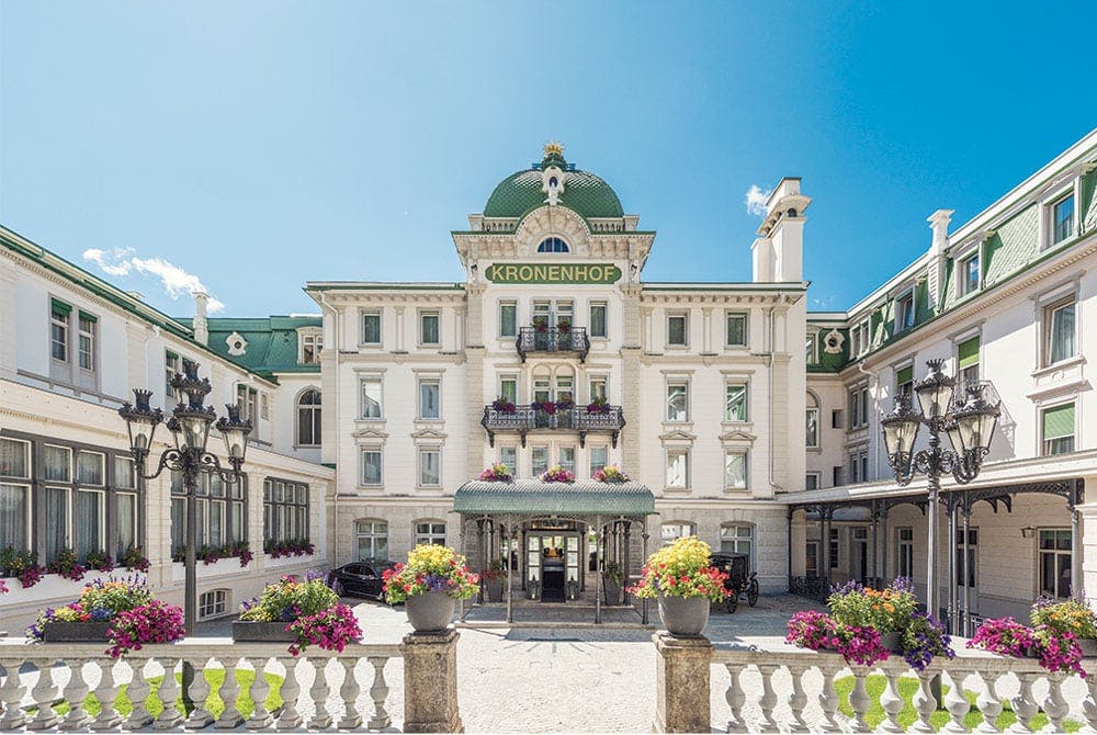 Beautiful hotel with courtyard and fence with flowers and green accents