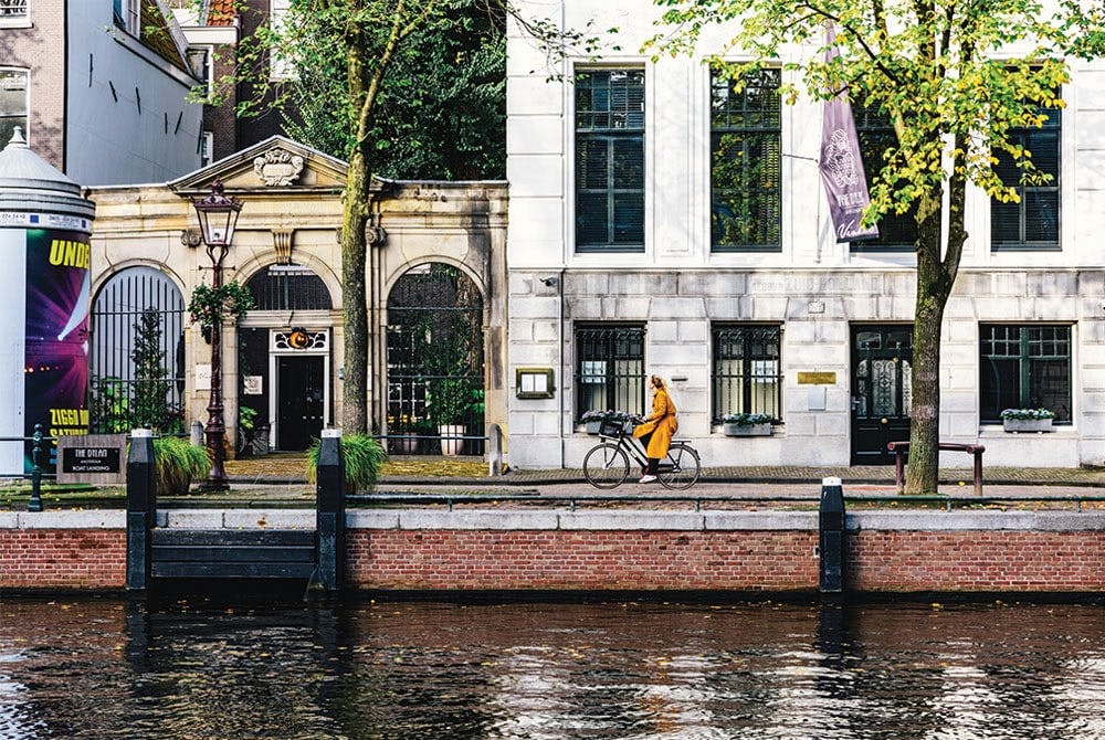 Dylan building along the waterway with someone on a bike outside