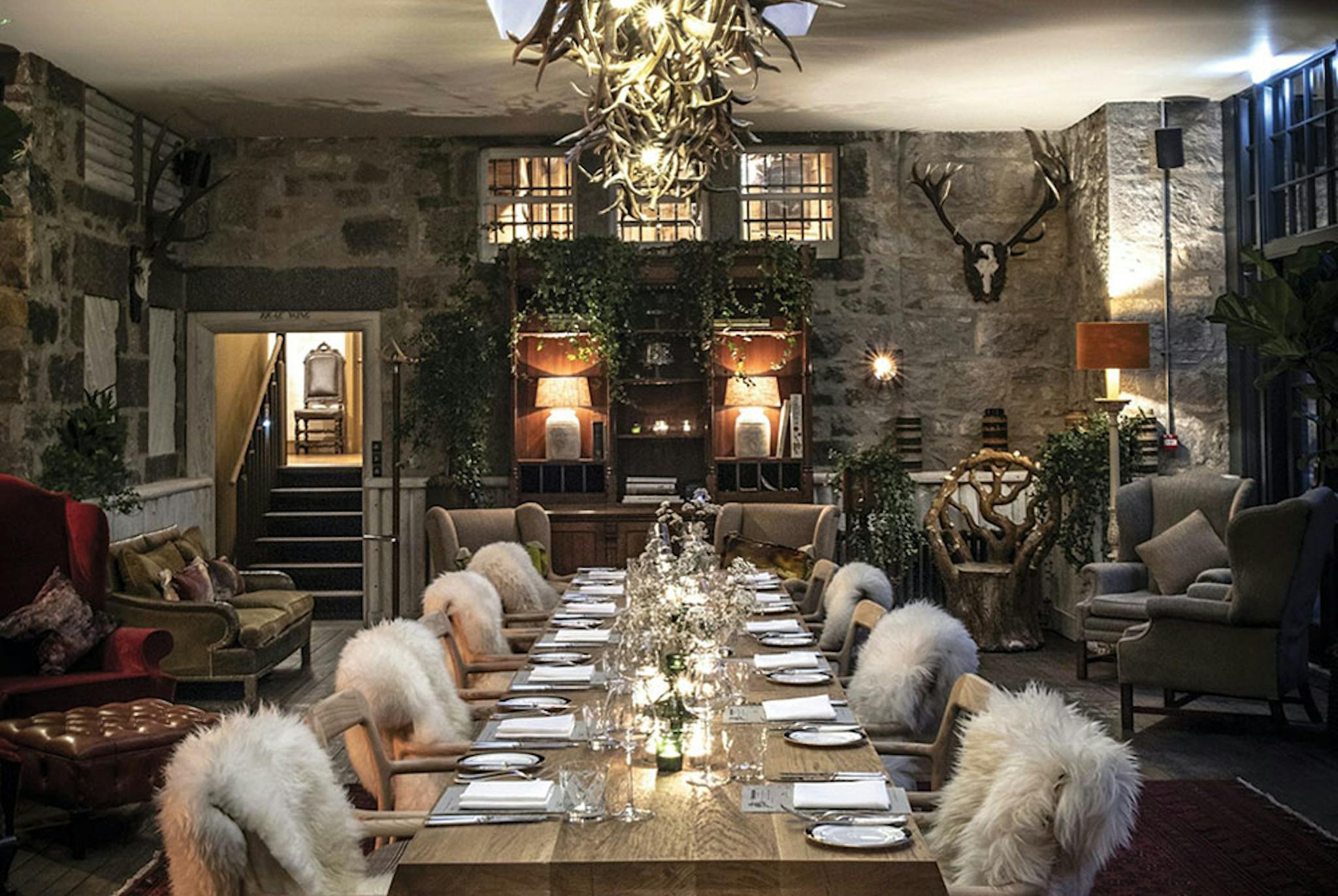 Cozy and dark interior dining table with furs draping over the seats