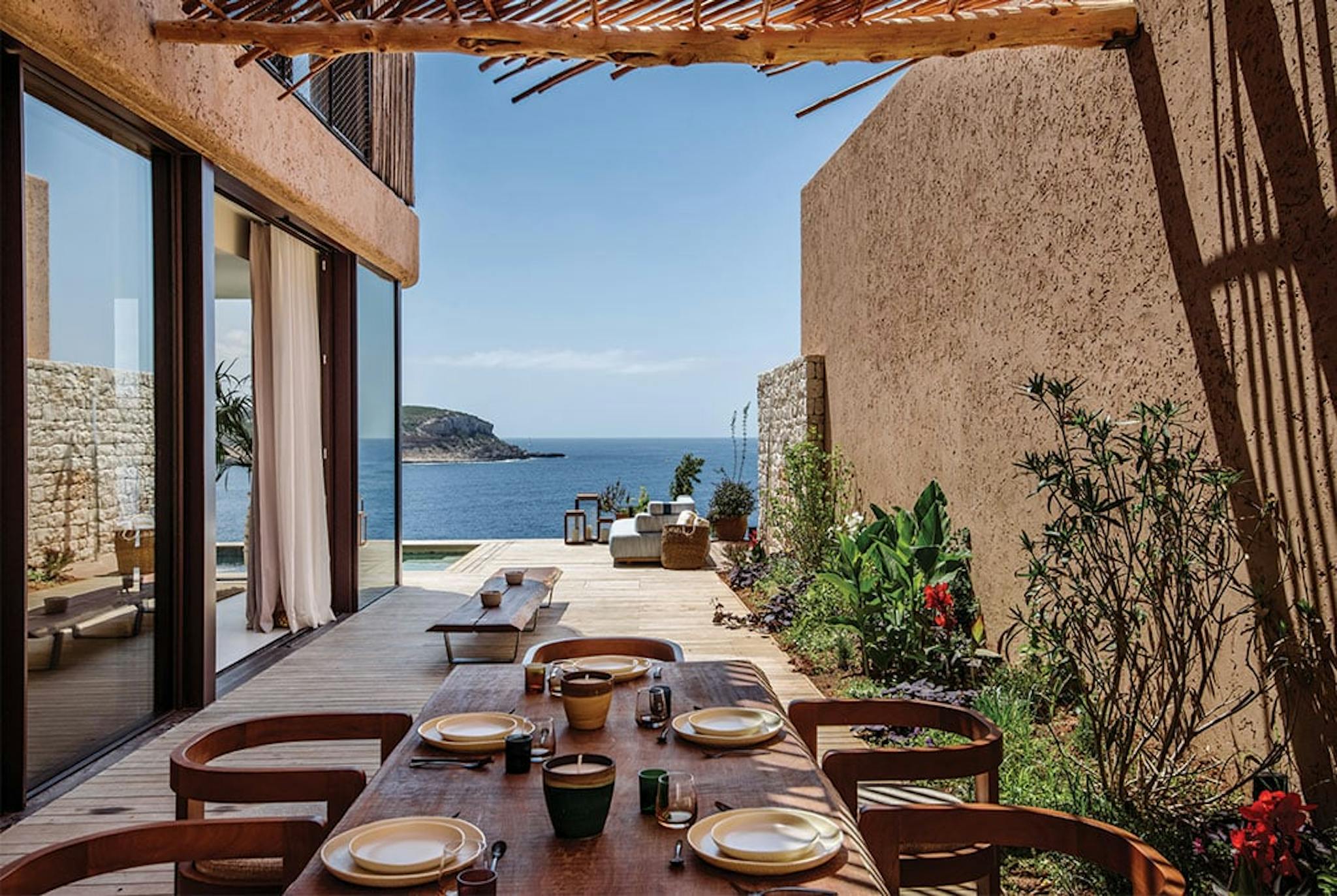 A table set in the courtyard overlooking the water through a hallway