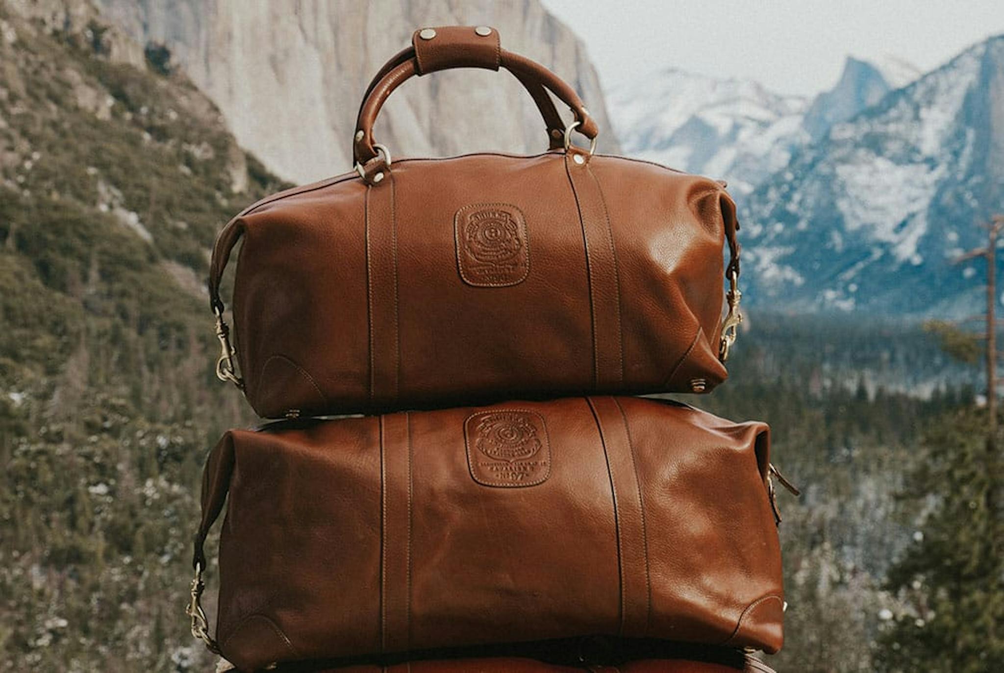 Stacked brown Ghurka bags fill the middle of the frame with mountainscape background