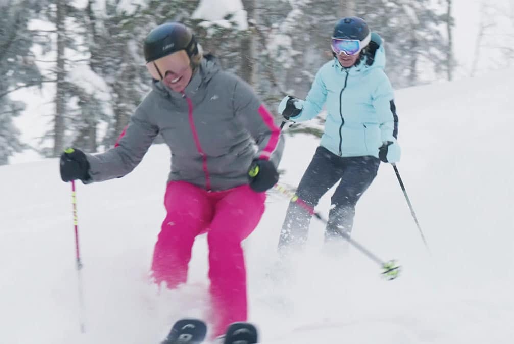 Two people ski in powdery snow
