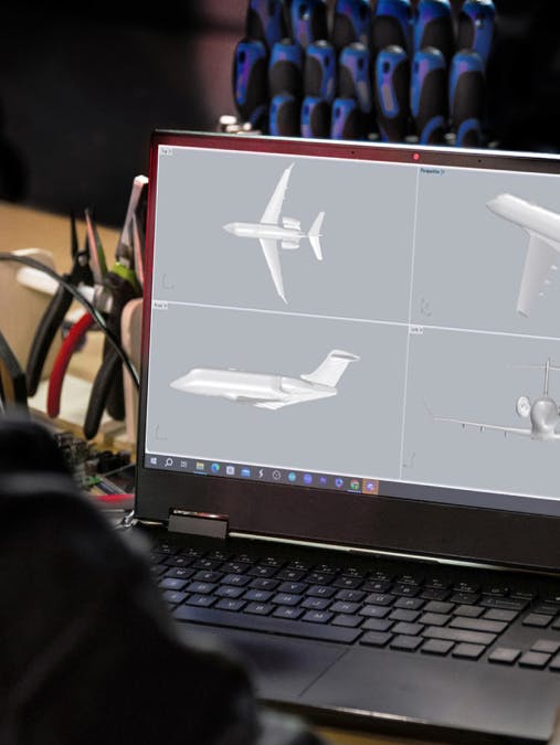 Over the shoulder of someone viewing a laptop screen with CGI aircraft images