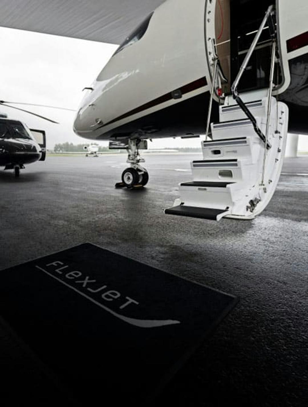 deployed stairs of an aircraft with a flexjet rug at the base