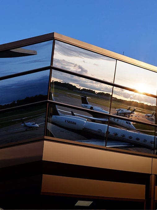 The building of Flexjet, closed up on the windows with the reflection of flexjet aircraft in the windows
