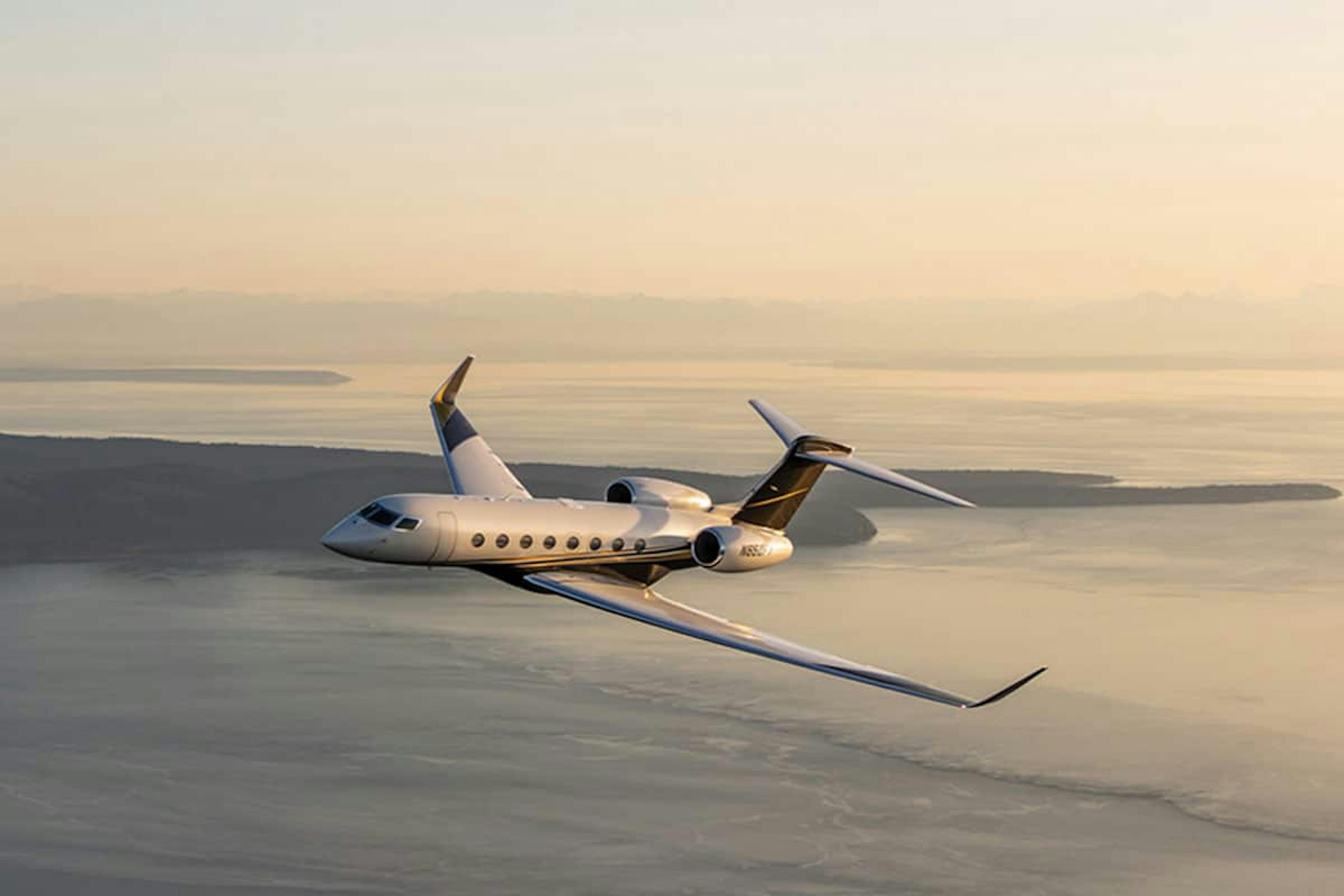 A flexjet aircraft tilts left over a bay of water, with a starlink box visible on the top