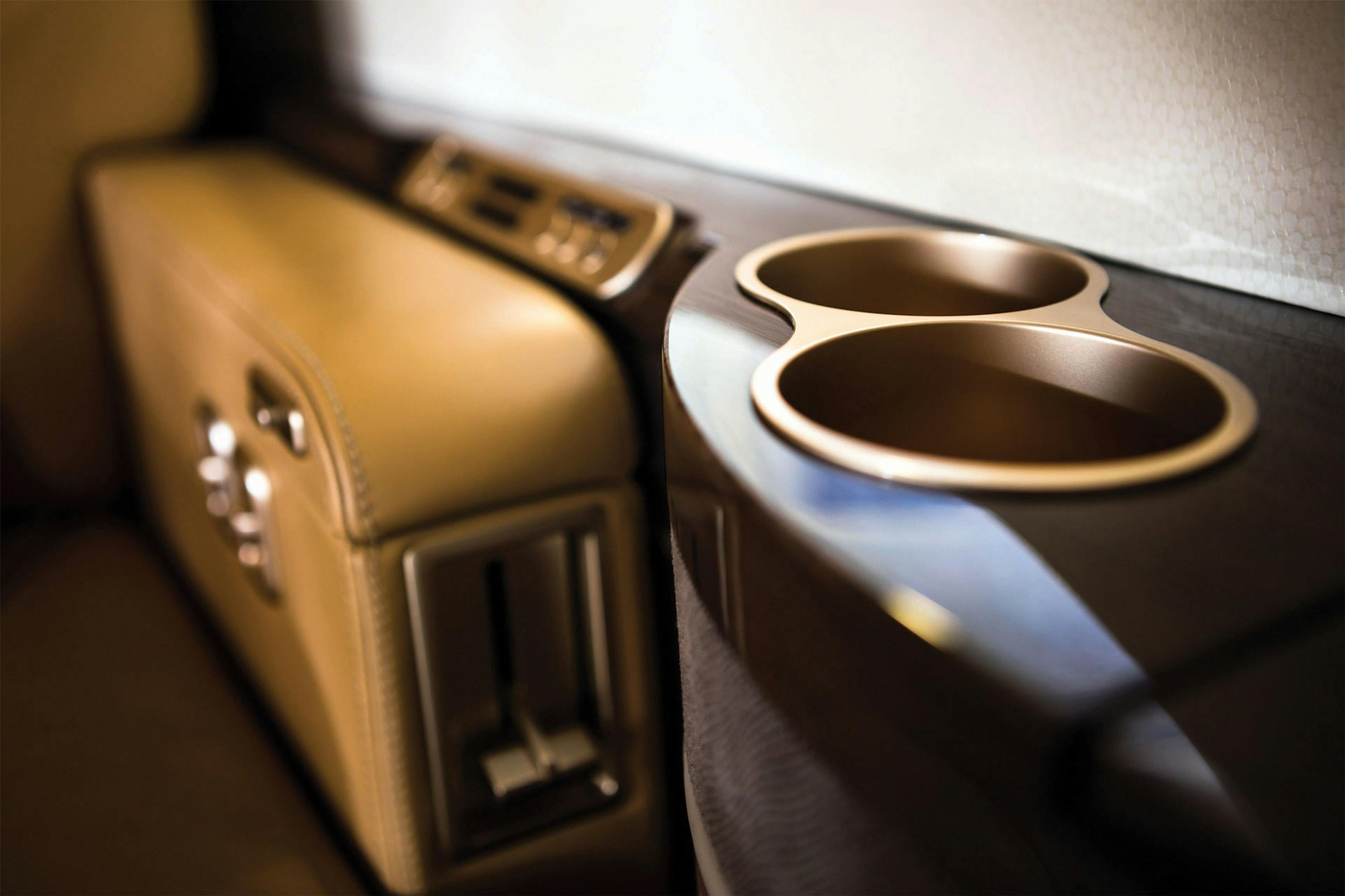 close up on the intricate armrest of the seating and metal rimmed cup holders